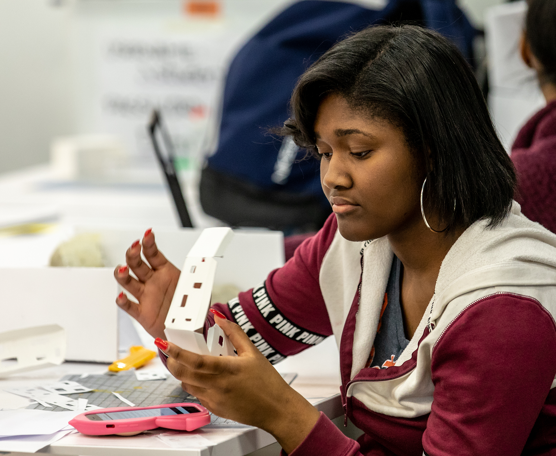 Student building a model at a small white table