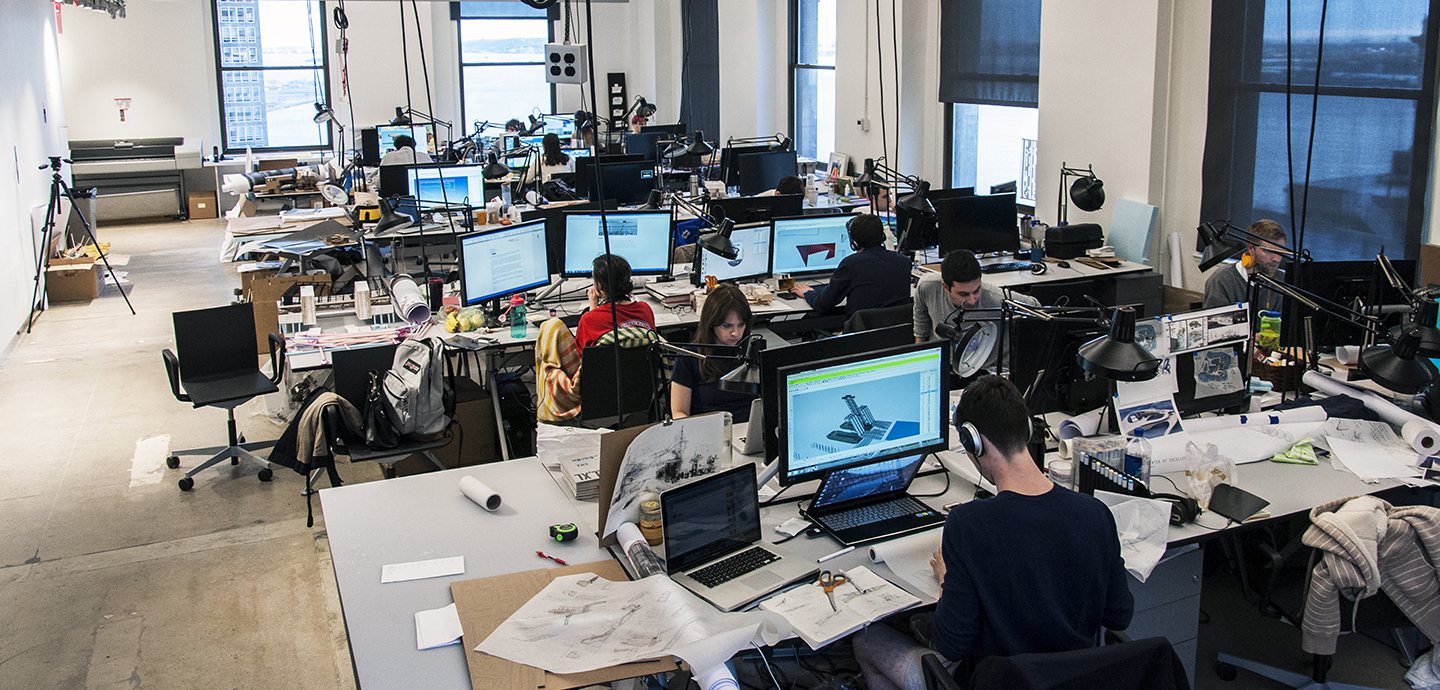studio with students working at computers and a view of New York City harbor