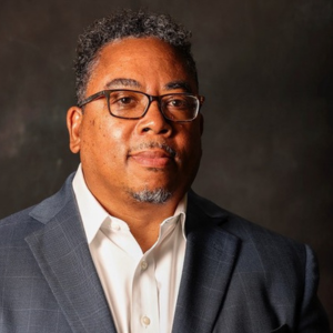 A man with glasses looking at the camera