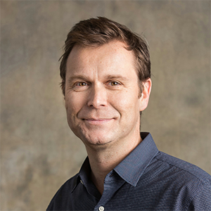 photo of person in blue collared shirt looking at the camera