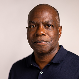 A man looking at the camera in front of a plain background