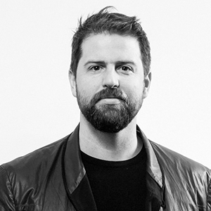 person with facial hair and a dark jacket