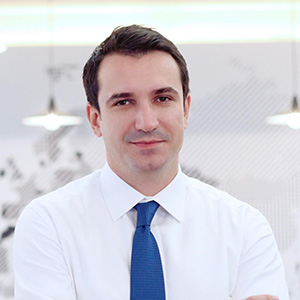 Person with arms crossed in white shirt and blue tie