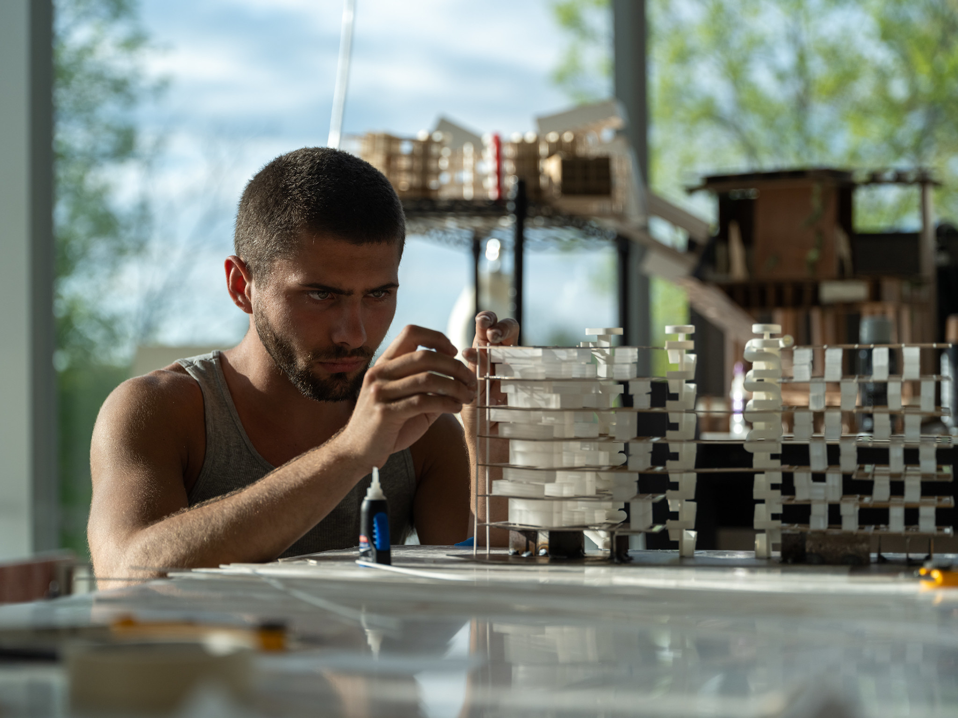 Student at a desk constructing a model