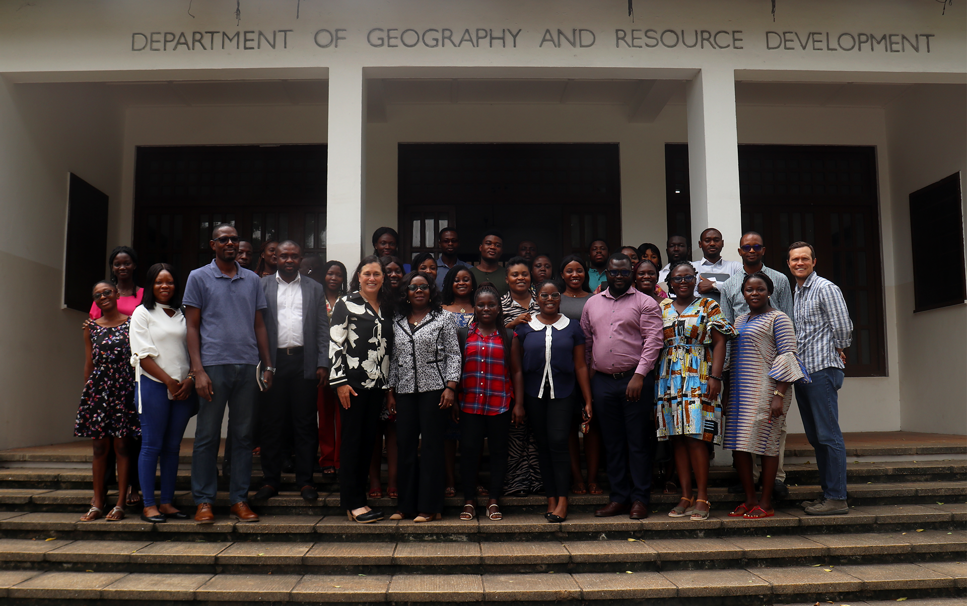 Group of people formally posed on outside building stairs