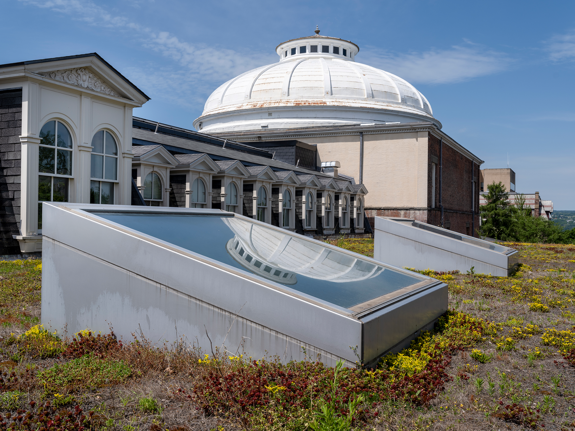 View of a white dome on top of a building viewed from an adjacent roof
