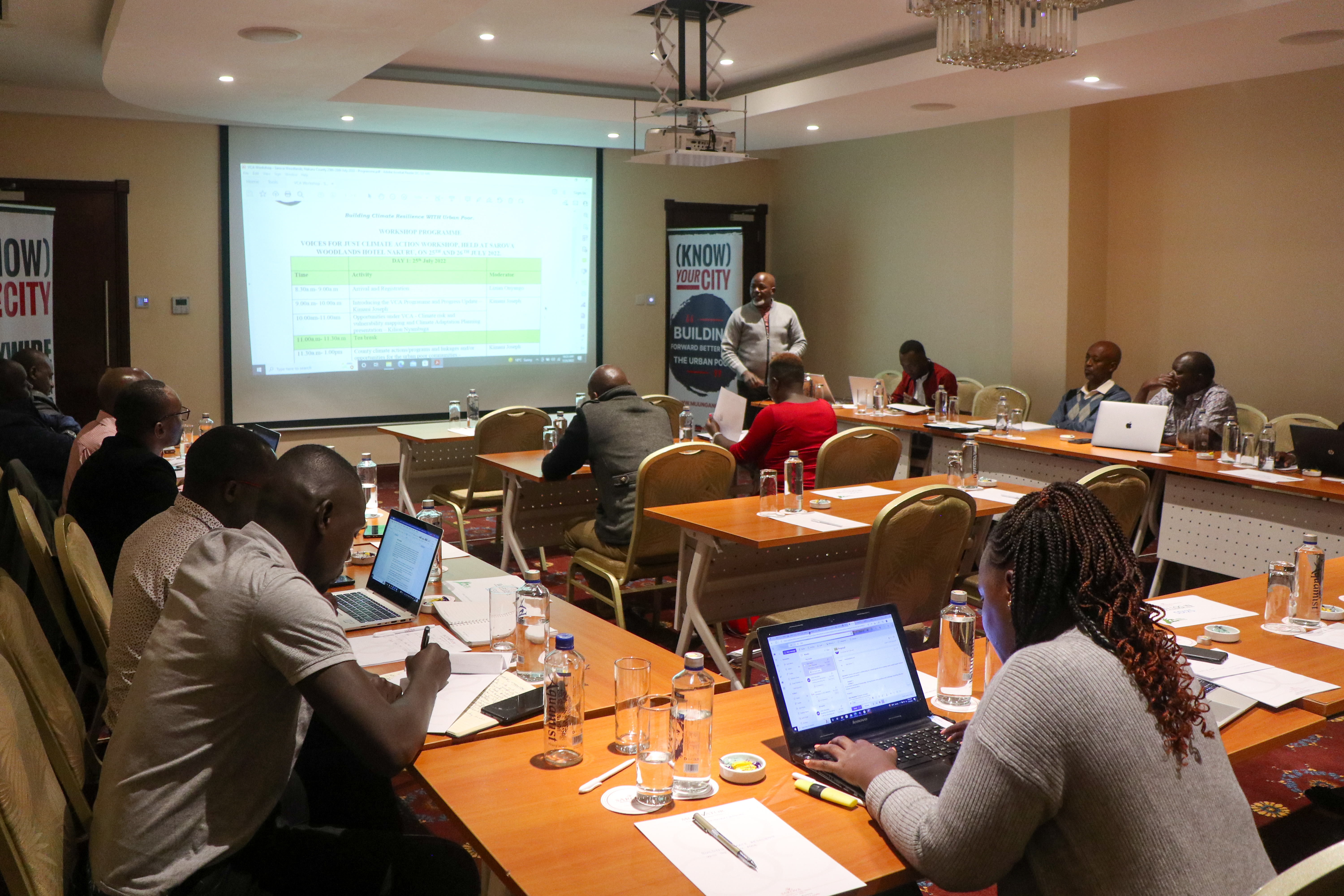 Group of people gathered in a conference room looking at a projected slide