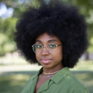 A person with curly hair looking at the camera