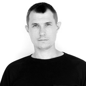 person with short dark hair and a dark top