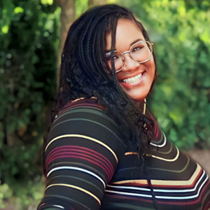 A woman with long braids smiling at the camera