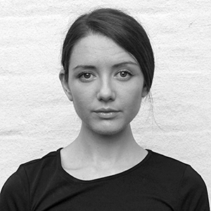 Person with dark hair wearing a dark top.