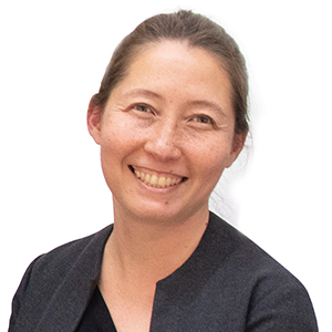 a person in a black short and hair pulled back smiling at the camera