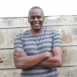 A person with a striped shirt and arms folded.