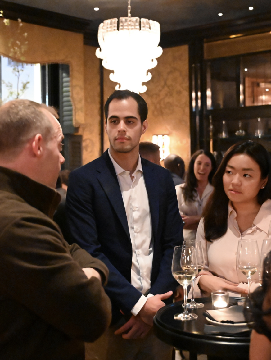 three people standing around a table talking