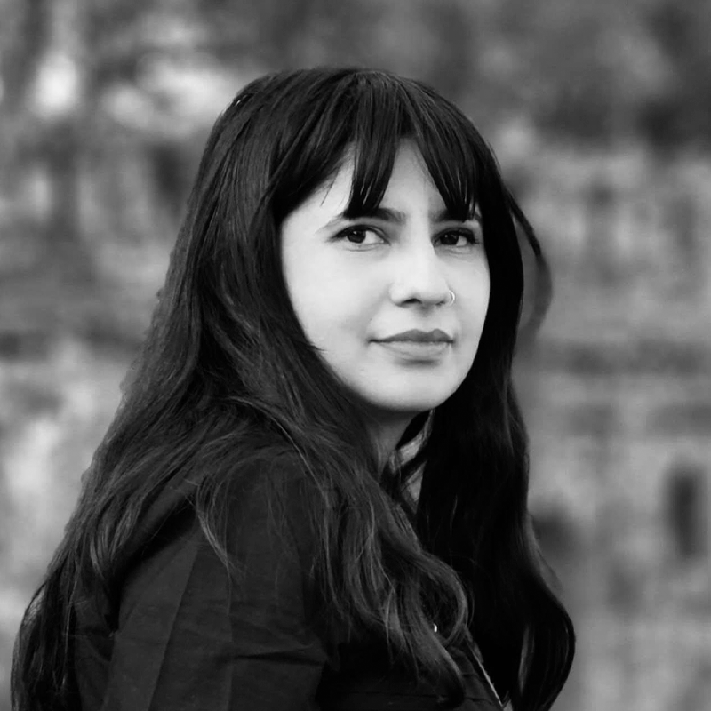 A black and white image of a woman with long dark hair and light skin.