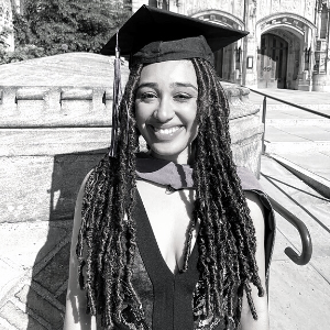Woman with long hair wearing graduation cap and sleeveless black dress