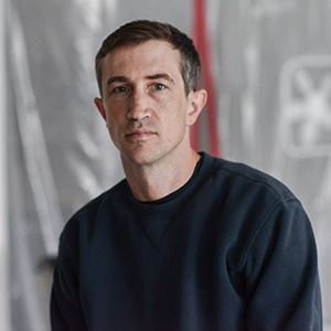 A person with short dark hair and a black shirt.