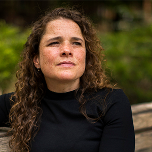 a person in a black blouse sitting on a bench 