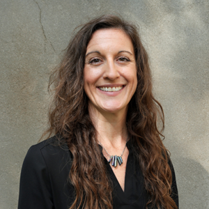 A smiling person with long wavy hair