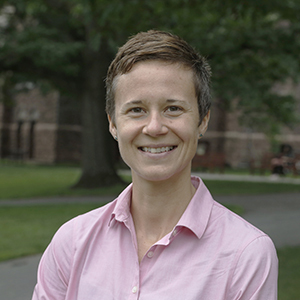 A person smiling, wearing a pink shirt