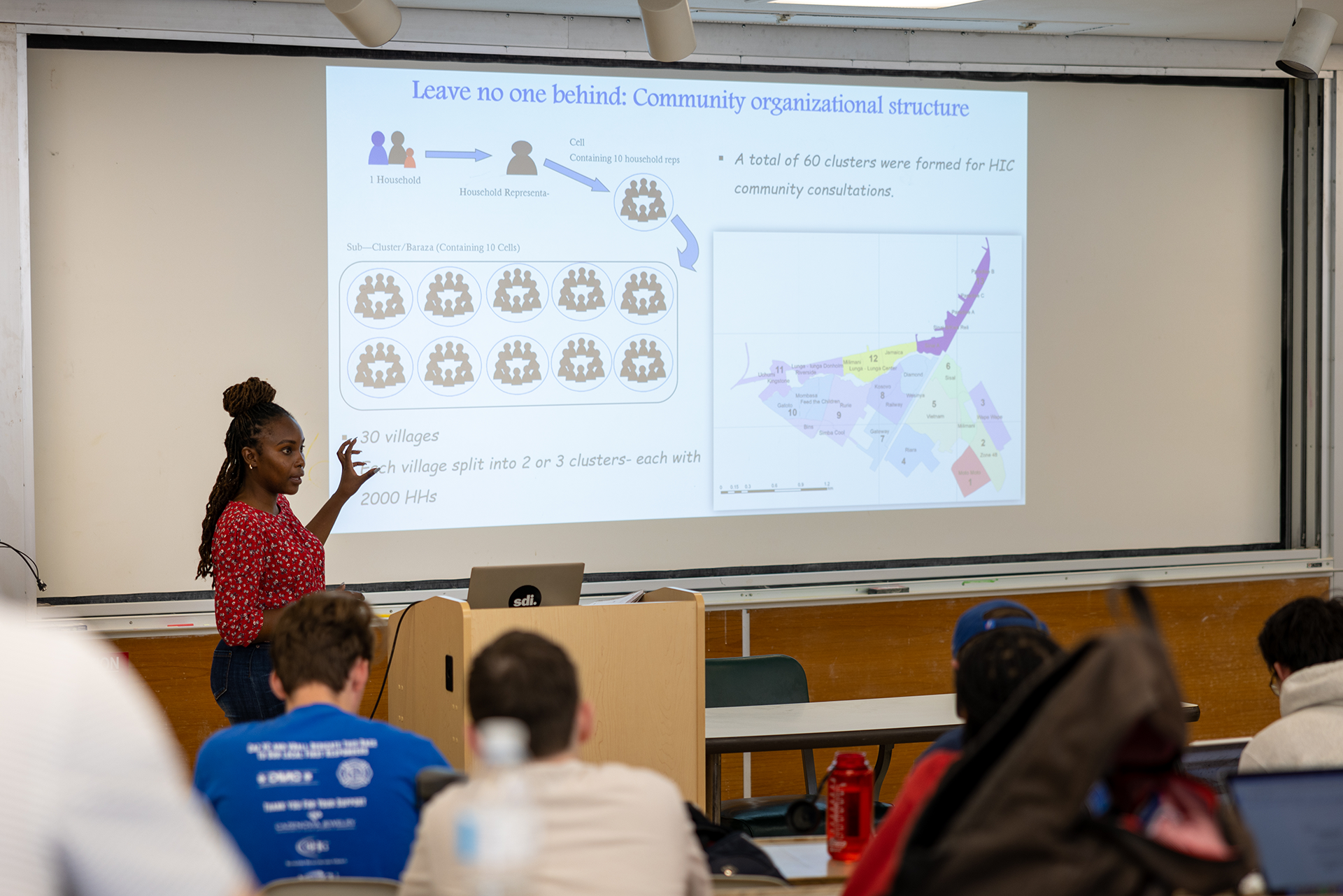 Woman lecturing in front of a projected chart