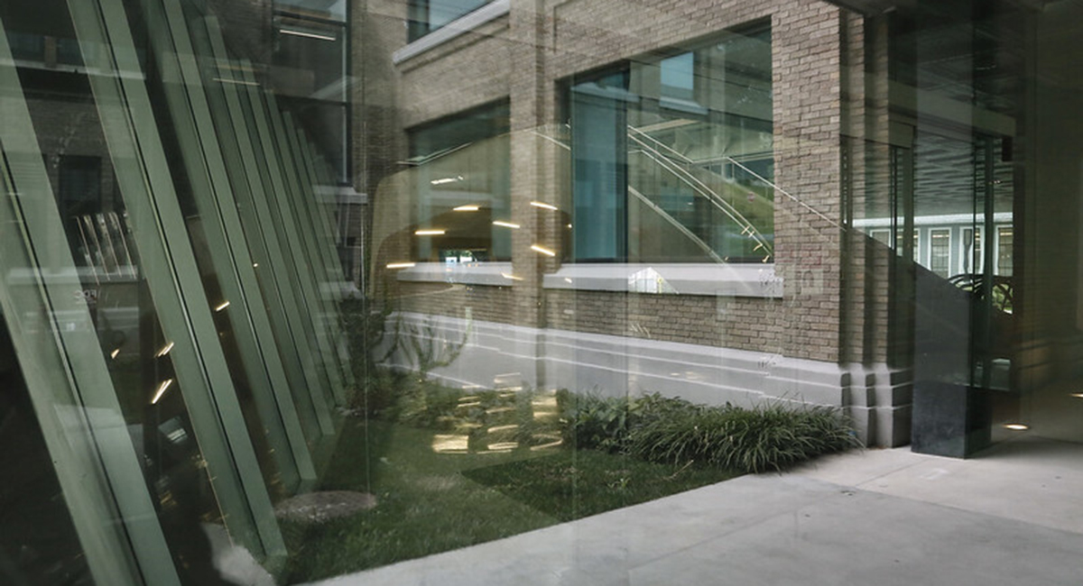 View of brick building through window with reflections