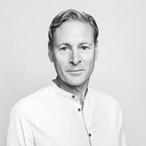 A man with short hair who is wearing a white button up shirt. 