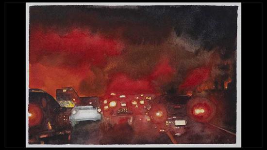 Many cars on a road at night with smoke and fire in the sky.