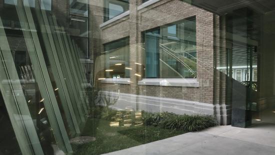 View of brick building facade through a window with glare from interior