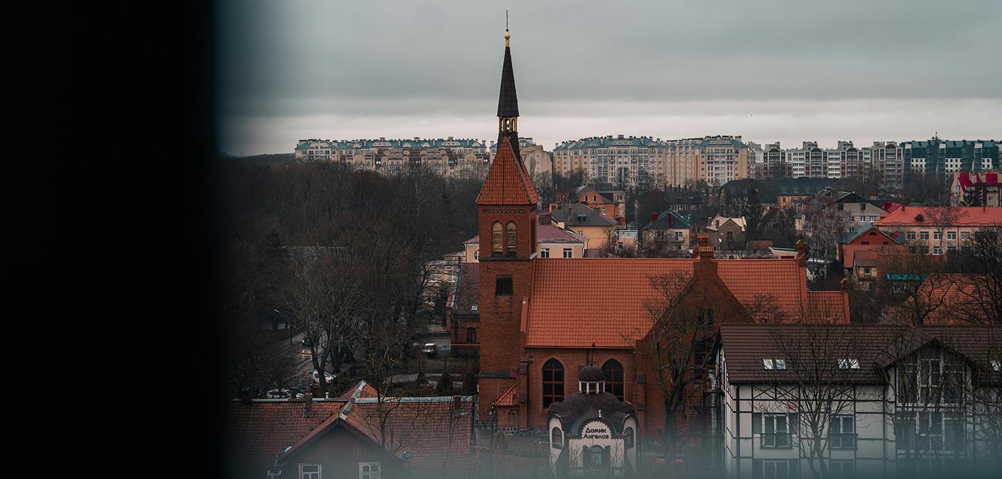 Preserved church steeple amidst modern apartments.