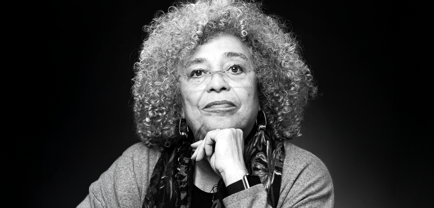 A black a white image of a brown skinned woman with long white curly hair.