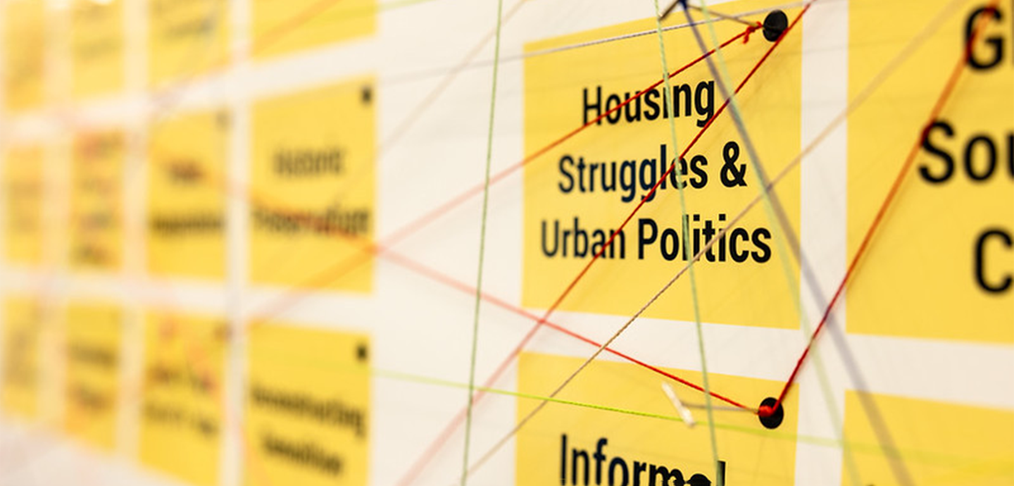 Yellow post it notes pined to a white wall.