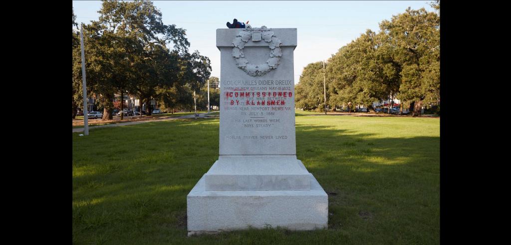 monument in a park surrounded by green trees and green grass.