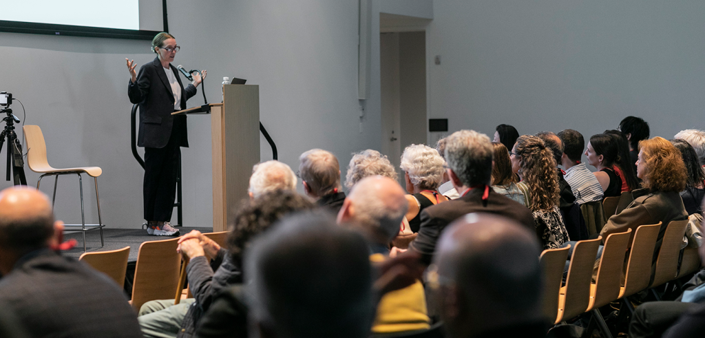 A person standing at a podium in front of a large crowd.