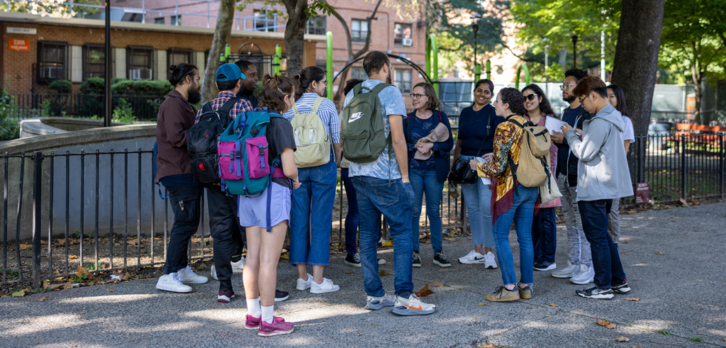 group of students gathered on a city sidewalk