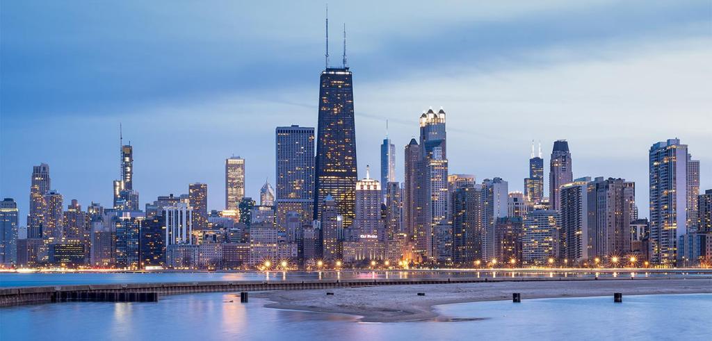 skyline of skyscrapers at dusk with water in front