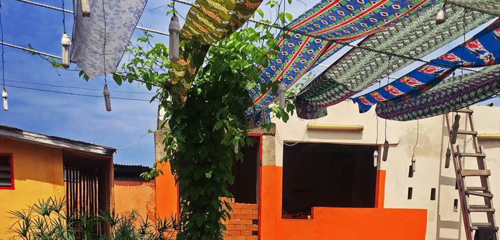 Colorful outdoor pavilion covered by series of draped colorful fabric. 
