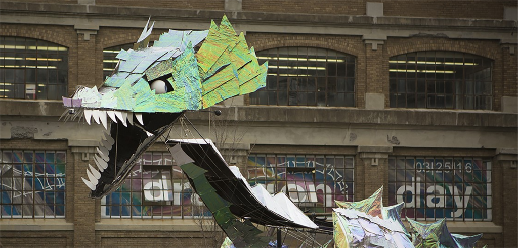 Model of a green dragon in front of a building