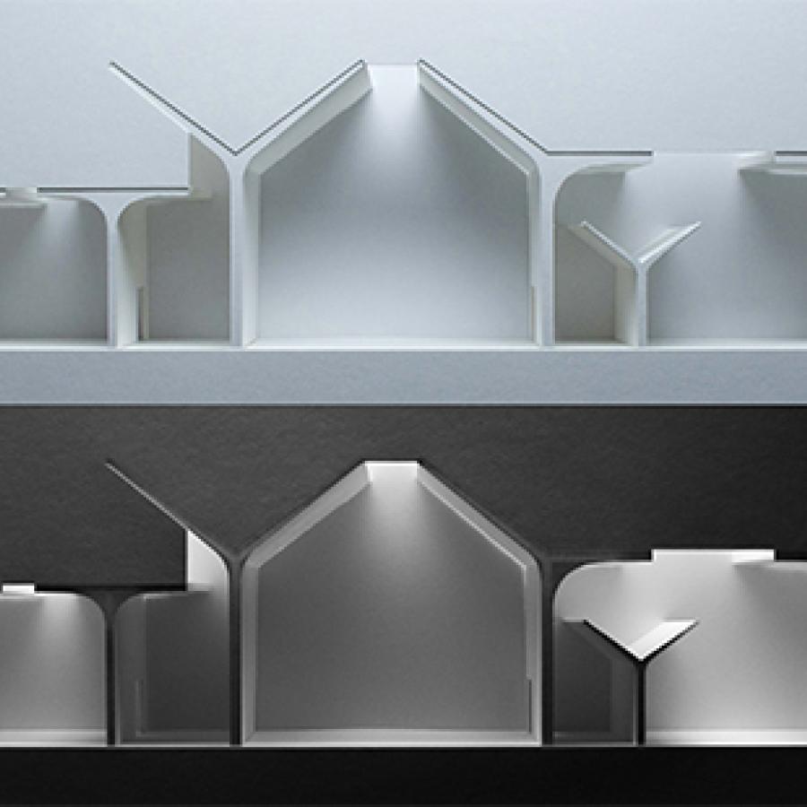 Two photographs of light-study models made out of white chipboard and paper materials showing section-cuts through proposal, with the bottom model being on a darker background and only being lit in the interior spaces. 
