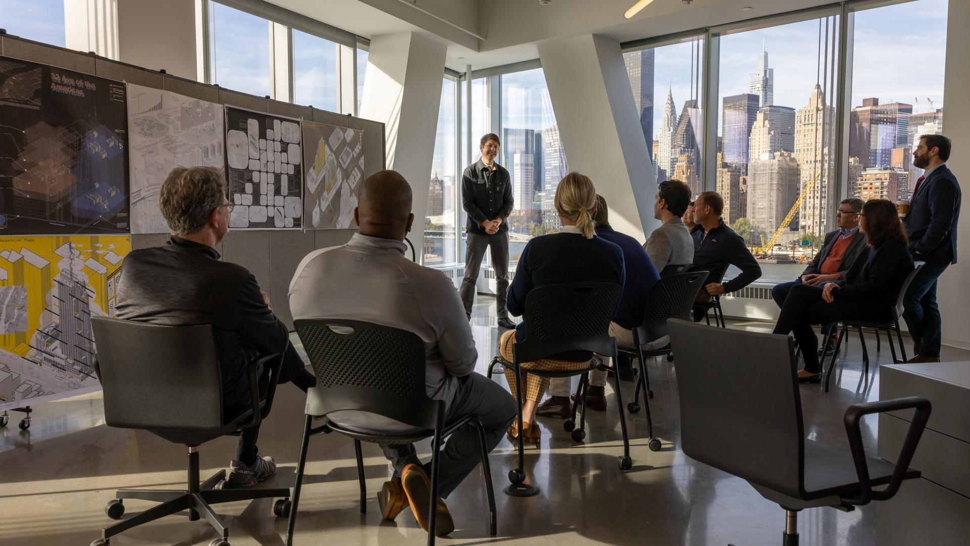 people sitting in a room listening to a speaker give a presentation