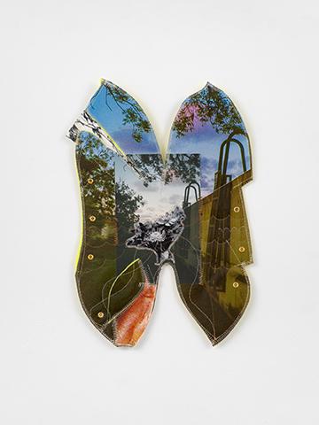 Abstract image featuring hues of green and branches of trees with leaves in a butterfly shape.