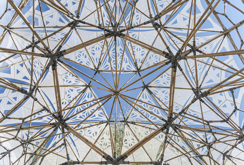An intricate geometrical structure made of bamboo logs connected through multiple joints.