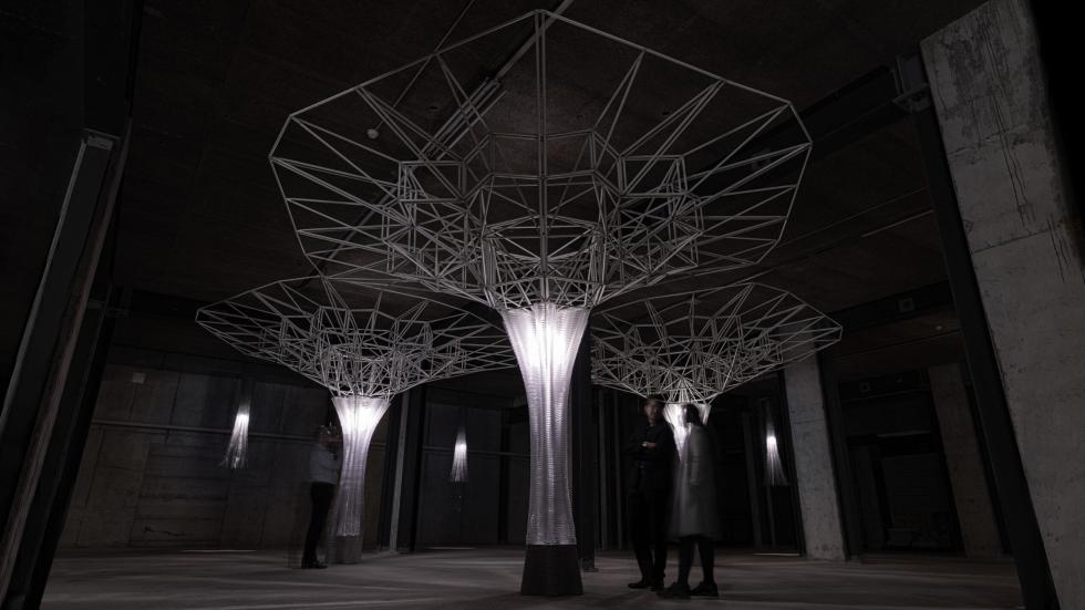 Three illuminated columns topped with intricate lattice structures.